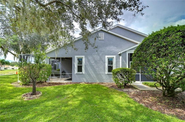 back of house with a yard and a sunroom