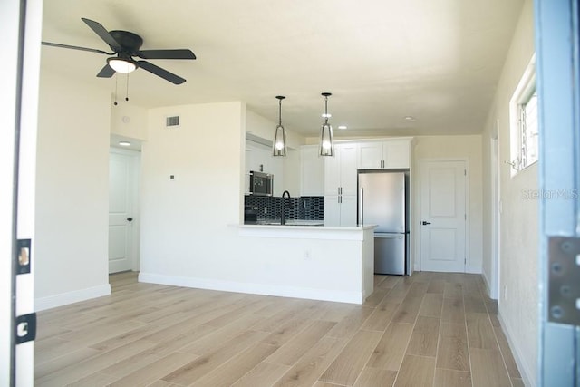 kitchen featuring appliances with stainless steel finishes, white cabinets, and light hardwood / wood-style floors