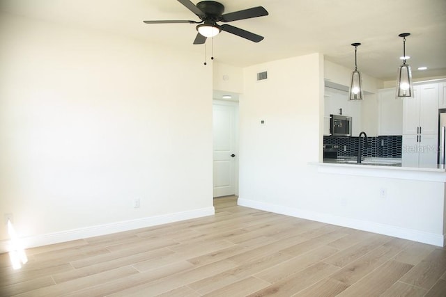 living room with light hardwood / wood-style floors, sink, and ceiling fan