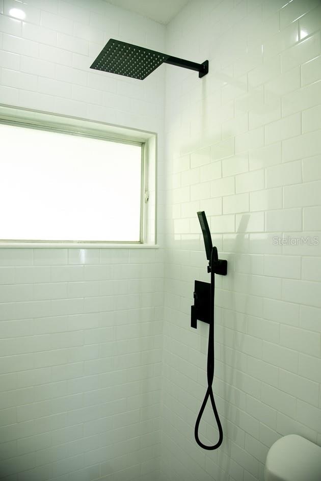 bathroom featuring toilet and tiled shower