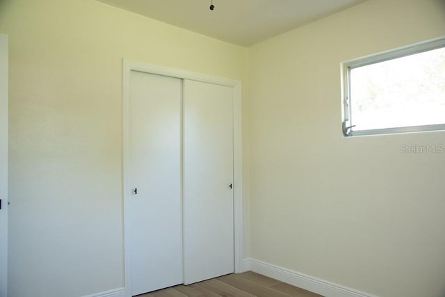 unfurnished bedroom featuring a closet and light wood-type flooring