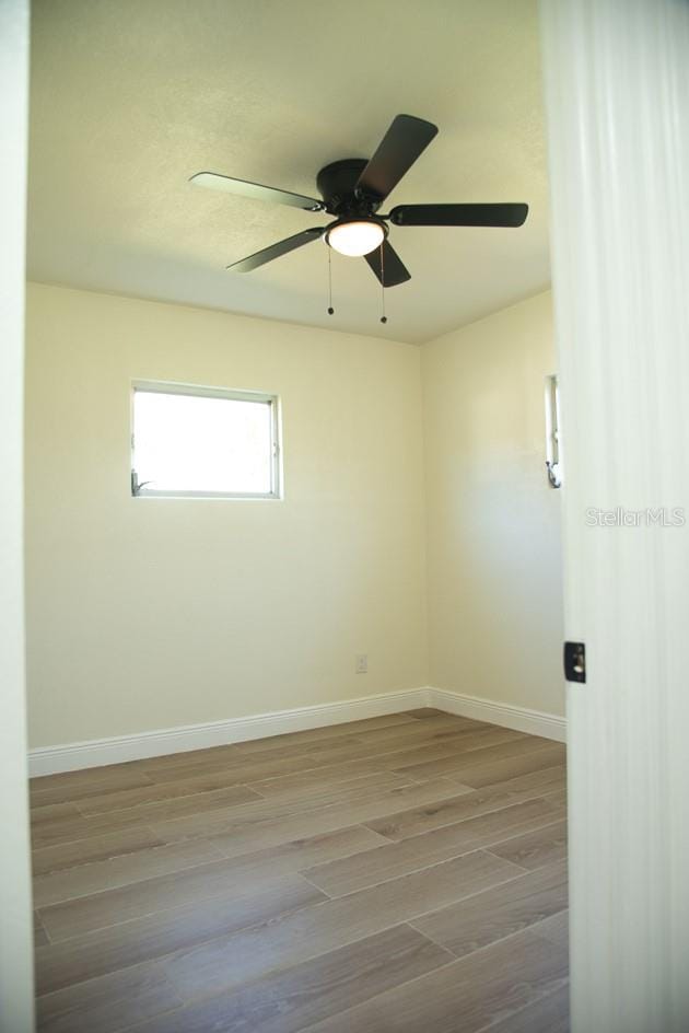 empty room with light hardwood / wood-style flooring and ceiling fan