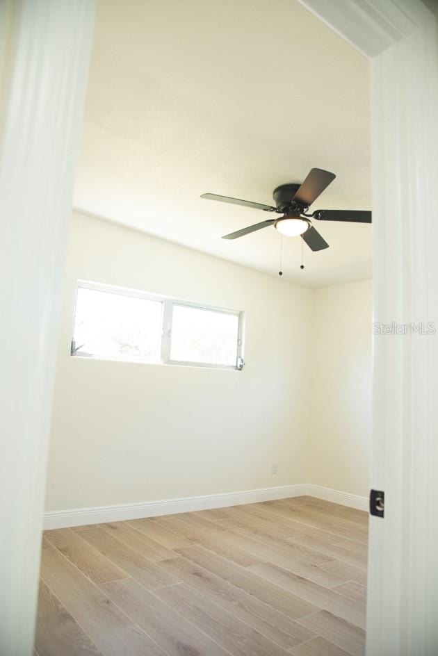 empty room with light wood-type flooring and ceiling fan