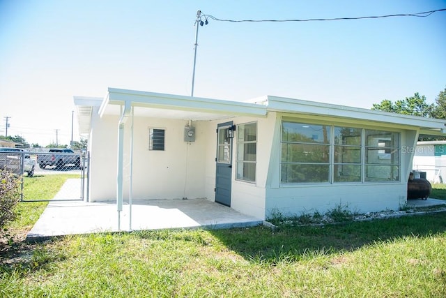 back of property with a patio and a lawn