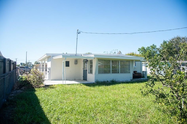 rear view of property with a yard and a patio