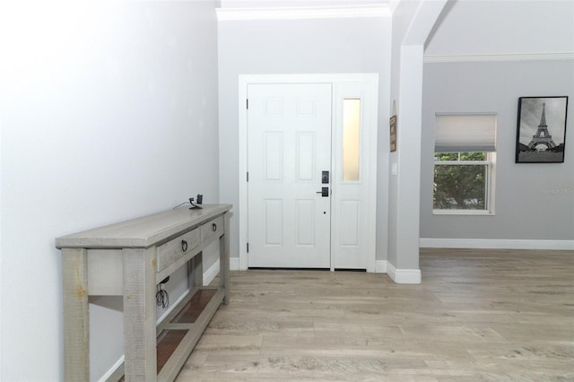 entrance foyer with light hardwood / wood-style floors and crown molding