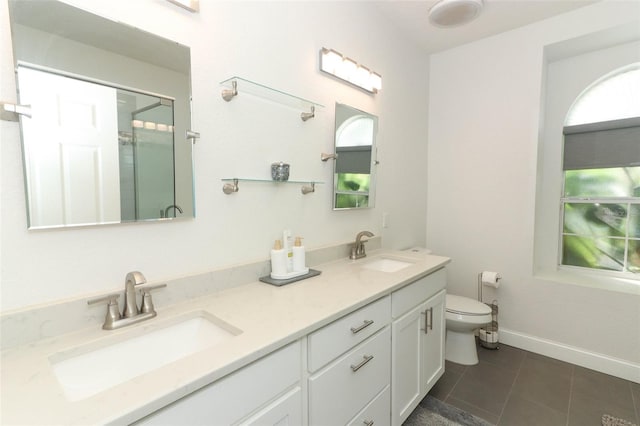 bathroom with an enclosed shower, vanity, tile patterned flooring, and toilet