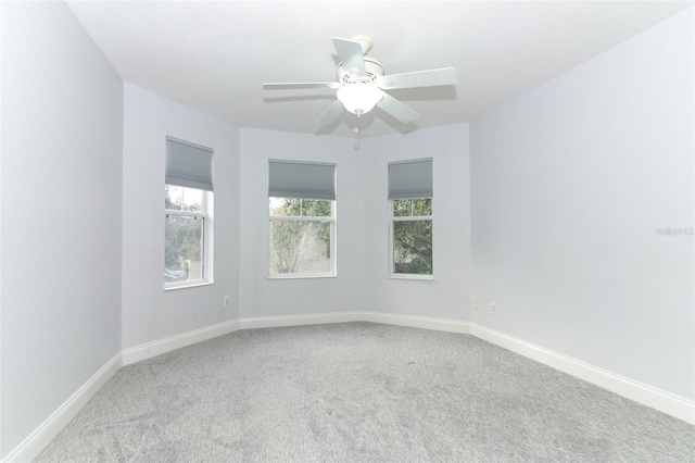 carpeted spare room featuring ceiling fan and a textured ceiling