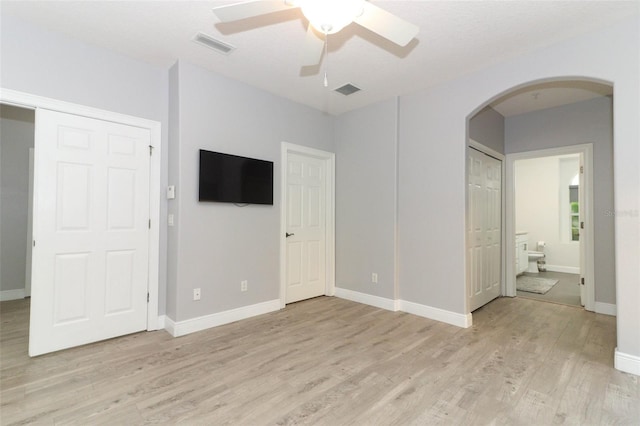 unfurnished bedroom with ensuite bath, ceiling fan, and light hardwood / wood-style flooring