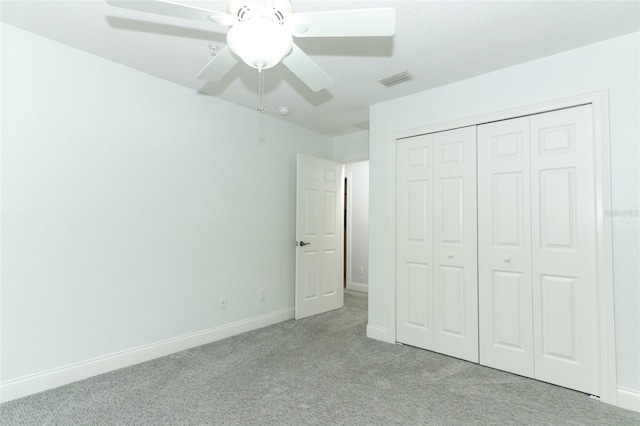 unfurnished bedroom with ceiling fan, a closet, and light carpet