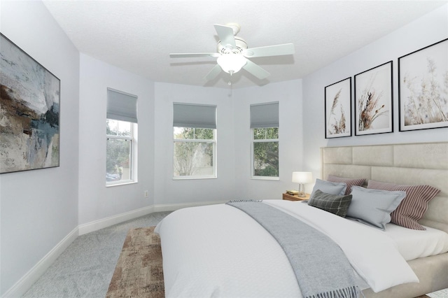 carpeted bedroom with ceiling fan and a textured ceiling