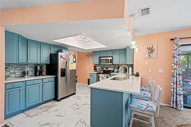 kitchen with kitchen peninsula, tasteful backsplash, stainless steel appliances, and hanging light fixtures