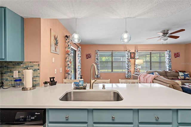 kitchen featuring black dishwasher, sink, decorative backsplash, and hanging light fixtures