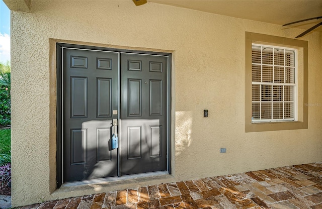 entrance to property with ceiling fan