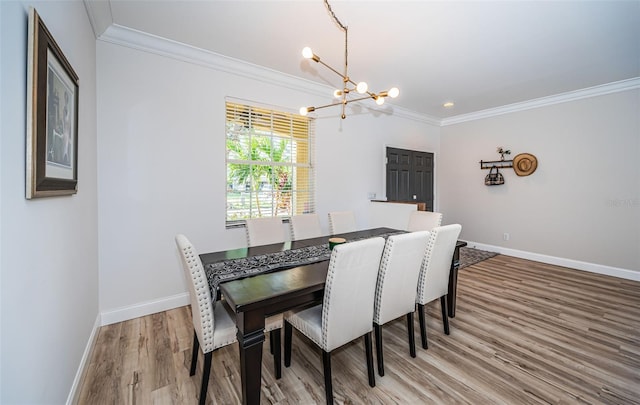 dining space with a notable chandelier, wood-type flooring, and ornamental molding