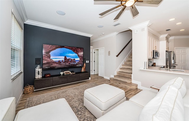 home theater with light hardwood / wood-style flooring, crown molding, ornate columns, and ceiling fan