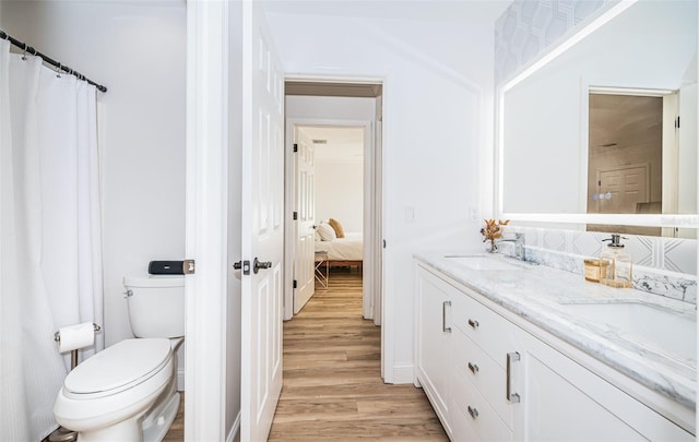 bathroom featuring vanity, hardwood / wood-style floors, and toilet