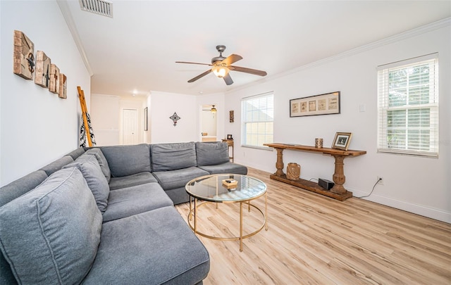 living room featuring ornamental molding, ceiling fan, plenty of natural light, and light wood-type flooring