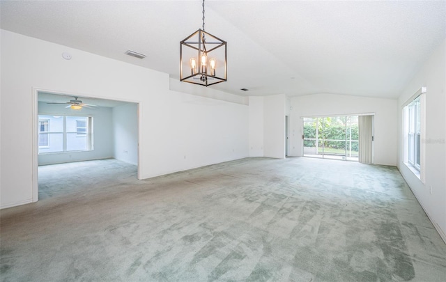 interior space with an inviting chandelier, vaulted ceiling, and light carpet