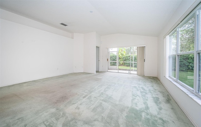 carpeted spare room featuring vaulted ceiling