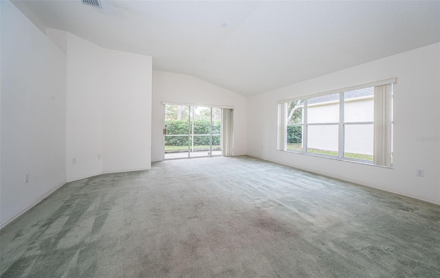 carpeted spare room featuring vaulted ceiling