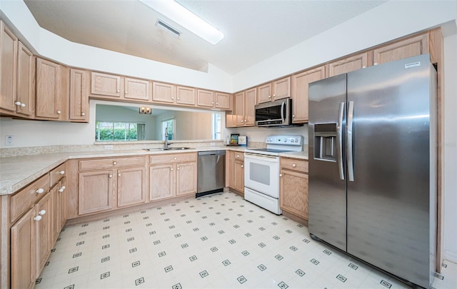 kitchen featuring lofted ceiling, sink, stainless steel appliances, and light brown cabinets