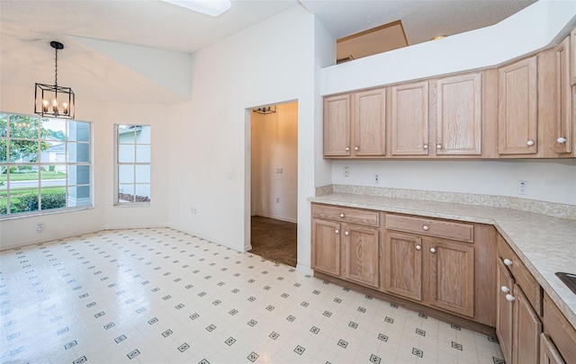 kitchen with decorative light fixtures, a chandelier, and high vaulted ceiling