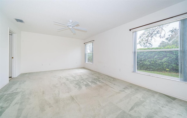 carpeted empty room featuring ceiling fan and a textured ceiling