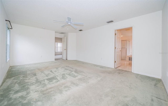 carpeted empty room featuring ceiling fan and a textured ceiling