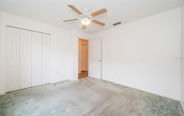 unfurnished bedroom with light carpet, a closet, and ceiling fan