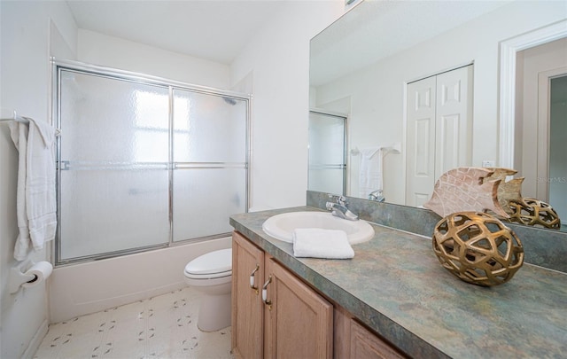 full bathroom featuring vanity, toilet, and combined bath / shower with glass door