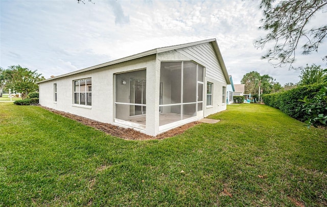 view of side of property with a sunroom and a yard