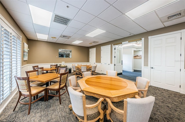 dining area with carpet and a paneled ceiling