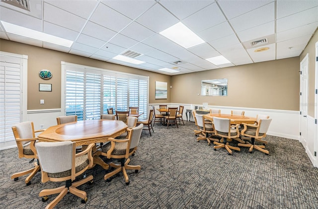 carpeted dining area featuring a drop ceiling