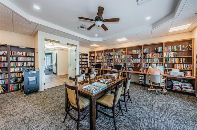 carpeted office space featuring ceiling fan