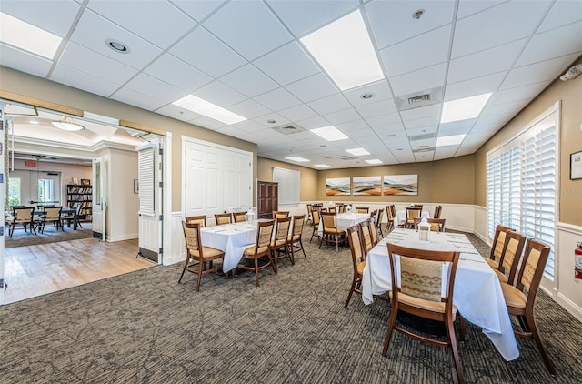 carpeted dining room featuring a drop ceiling