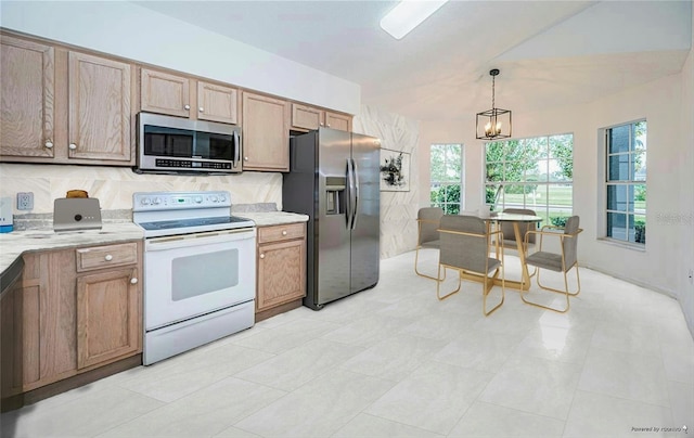 kitchen with lofted ceiling, stainless steel appliances, a chandelier, and hanging light fixtures