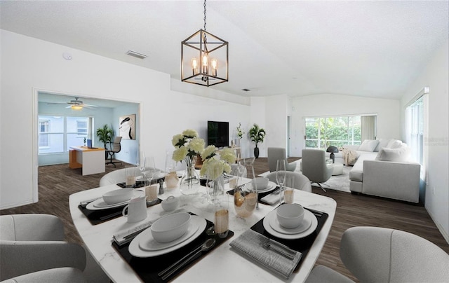 dining space with lofted ceiling, dark hardwood / wood-style floors, a textured ceiling, and an inviting chandelier