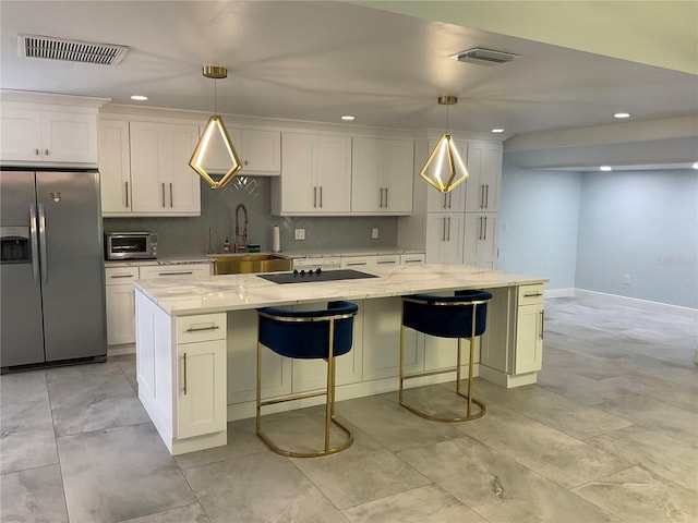 kitchen featuring a large island, sink, hanging light fixtures, and stainless steel appliances