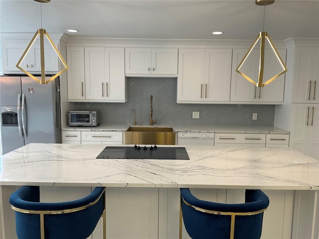 kitchen with sink, tasteful backsplash, decorative light fixtures, and white cabinets