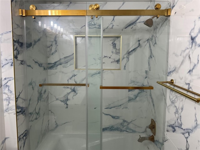 bathroom with combined bath / shower with glass door