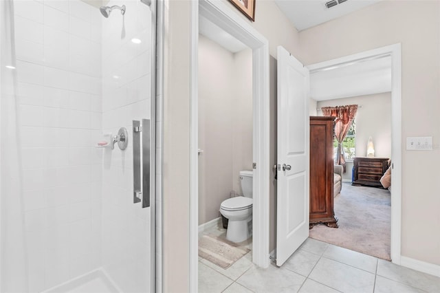 bathroom featuring a shower with door, toilet, and tile patterned floors