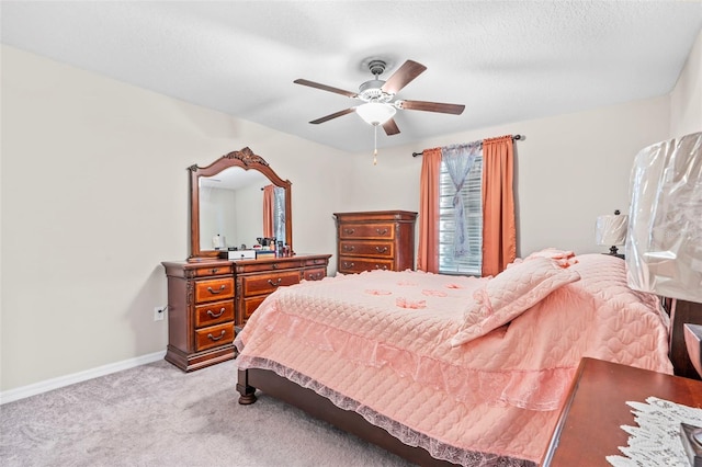 carpeted bedroom featuring a textured ceiling and ceiling fan