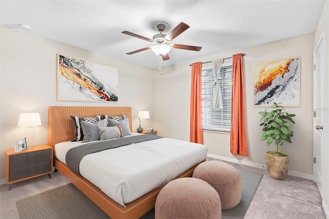 bedroom with light carpet, a textured ceiling, and ceiling fan