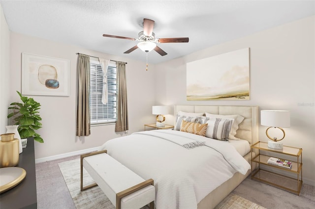 bedroom featuring ceiling fan, light carpet, and a textured ceiling