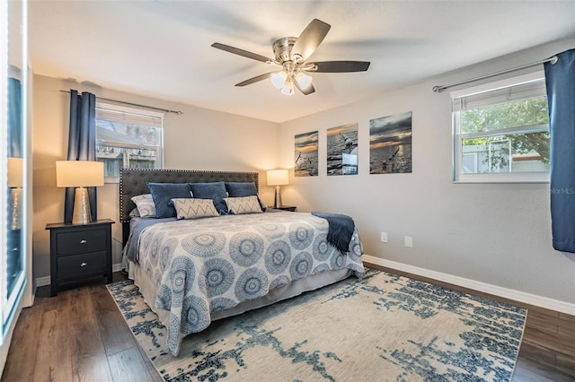 bedroom featuring multiple windows, dark hardwood / wood-style floors, and ceiling fan