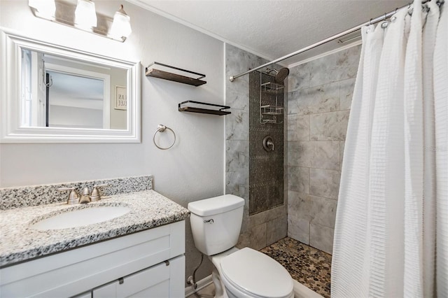 bathroom featuring toilet, a textured ceiling, a shower with curtain, and vanity