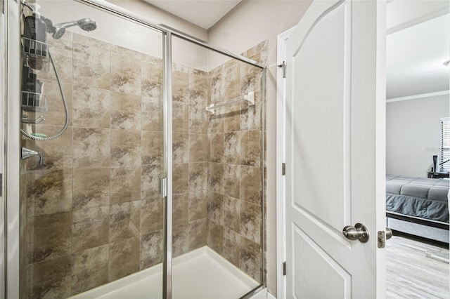 bathroom featuring a shower with door and ornamental molding