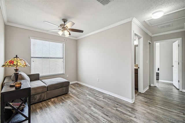 living area featuring ornamental molding, hardwood / wood-style floors, a textured ceiling, and ceiling fan