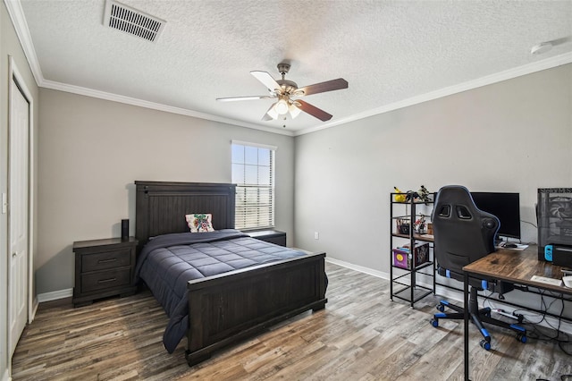 bedroom with ornamental molding, hardwood / wood-style floors, a textured ceiling, and ceiling fan